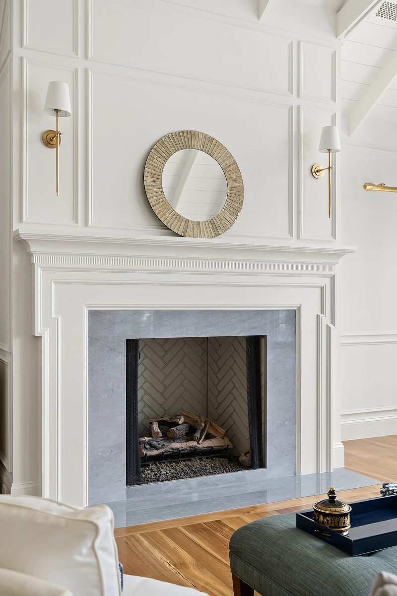 Fireplace with custom tiling, trim, and mantle, next to hardwood floor.
